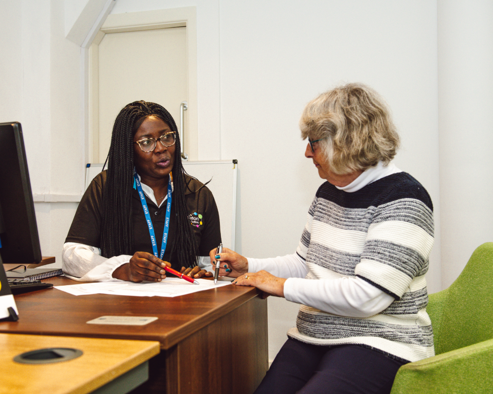two women in a room chatting about a form